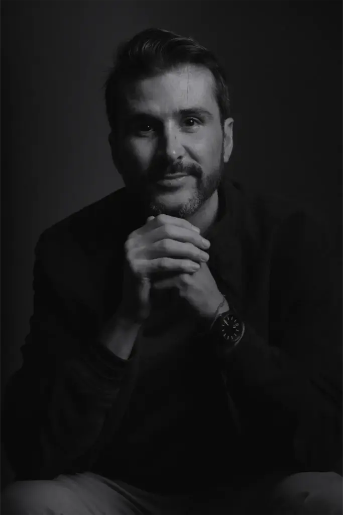 Dark headshot of man resting chin on hands